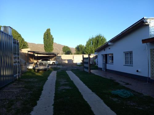 an empty yard next to a house and a building at CASA PARA ALQUILER LA LILI in Uspallata