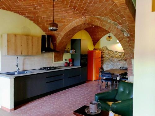 a kitchen with a brick wall and a kitchen with a table at L'Oliviera, Pari in Pari