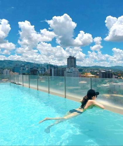 uma mulher numa piscina no topo de um edifício em Mabolo Garden Flats em Cebu