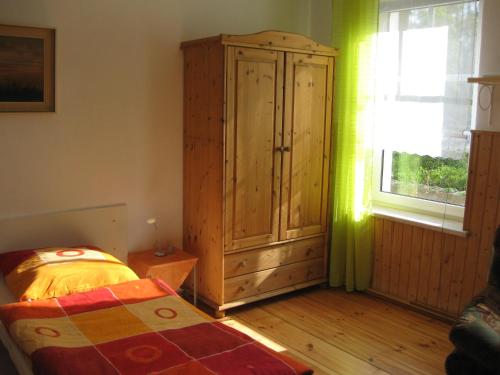 a bedroom with a wooden cabinet and a bed at Spreewaldunterkunft Buchecker in Lübben