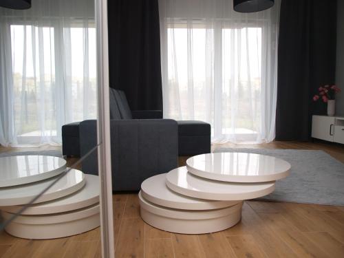 un soggiorno con 2 tavoli bianchi e un divano di Apartment Talarowa Delux a Varsavia