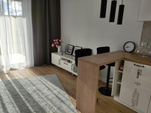una camera con scrivania, due sedie e un orologio di Apartment Talarowa Delux a Varsavia