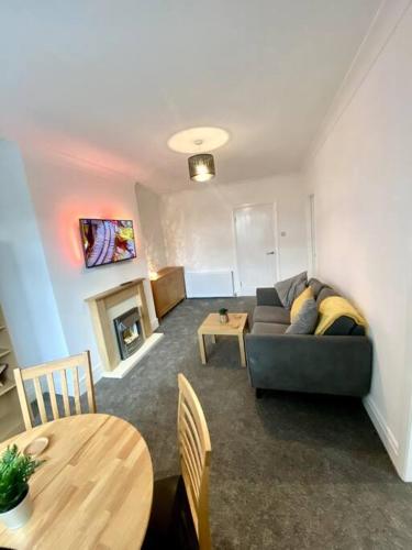 a living room with a couch and a table at Private Northumberland Apartment - FREE PARKING in Cowpen