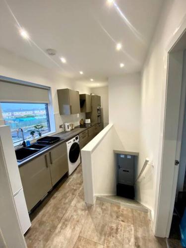 a white kitchen with a sink and a dishwasher at Private Northumberland Apartment - FREE PARKING in Cowpen