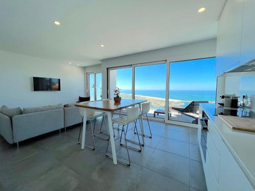 a kitchen and dining room with a view of the ocean at Ocean Views - New Private Condominium with Pool & Sea Views in Nazaré