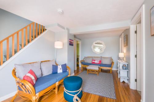 een woonkamer met een blauwe bank en een trap bij 277 Phillips Road Sandwich - Cape Cod in Sagamore Beach