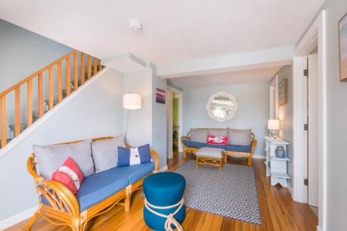 a living room with a blue couch and a staircase at 277 Phillips Road Sandwich - Cape Cod in Sagamore Beach