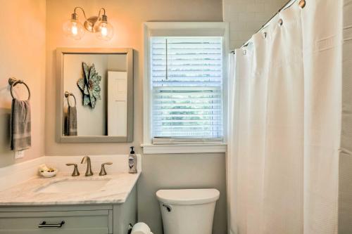 a bathroom with a toilet and a sink and a window at Modern Southern Comforts Home Near Charleston in Charleston