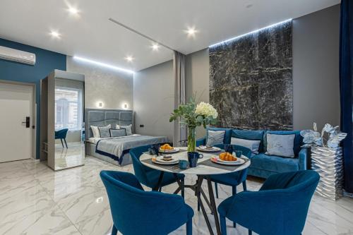 a living room with a blue couch and a table and chairs at Family Residence Boutique Apartments in Lviv
