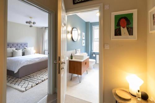 a bedroom with a bed and a bathroom with a sink at The Taproom in Scarborough