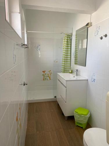 Baño blanco con lavabo y espejo en Stay Porto Côvo II, en Porto Covo