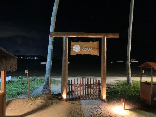 a sign for a hotel on the beach at night at Vizinho à igrejinha - Apartamento completo no ECO RESORT Praia dos Carneiros in Praia dos Carneiros