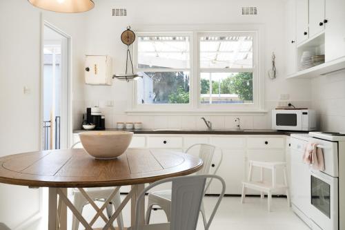 a kitchen with a wooden table and white cabinets at The Seaside Cobbler in Rye