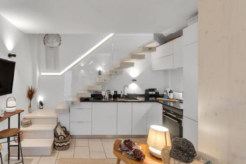una cucina con armadietti bianchi e una scala di Casa Mimi by Larimar a Olhão