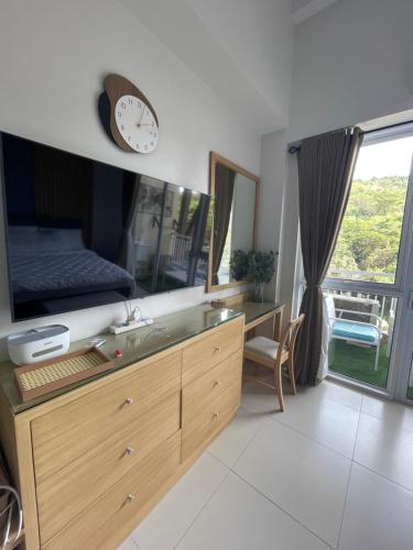 La salle de bains est pourvue d'un lavabo et d'une horloge murale. dans l'établissement 1BD 1BA PENTHOUSE 2X QUEEN, à Nasugbu