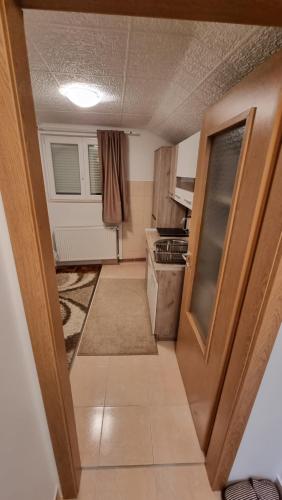 una pequeña cocina con una puerta que da a una habitación en Fortress apartments Niš, en Niš