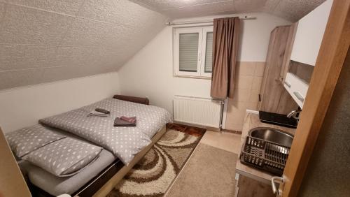 ein kleines Schlafzimmer mit einem Bett und einem Waschbecken in der Unterkunft Fortress apartments Niš in Niš
