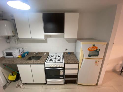 a small kitchen with a stove and a refrigerator at Depto zona centro muy comodo. in Rosario