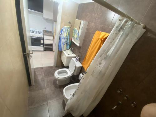 a small bathroom with two toilets and a sink at Depto zona centro muy comodo. in Rosario