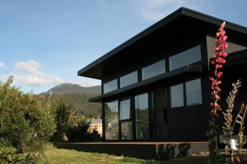 a black house with glass windows in a yard at Shibui Lilydale Luxury Romance in Lilydale