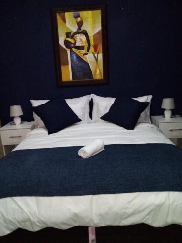 1 dormitorio con 1 cama grande y paredes azules en Kwa-Ntokozo Guesthouse-Tweefontein, en Tweefontein