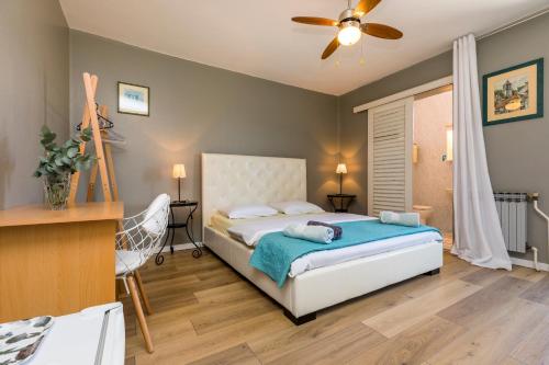a bedroom with a bed and a ceiling fan at Apartments and rooms with parking space Mali Losinj (Losinj) - 2495 in Mali Lošinj