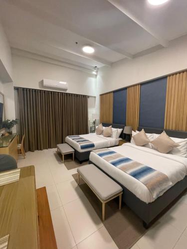 Habitación de hotel con 2 camas y sofá en 1BD 1BA PENTHOUSE 2X QUEEN en Nasugbu