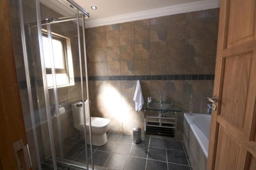 a bathroom with a shower and a toilet and a tub at Uitsigpark Guest@home4U in Centurion