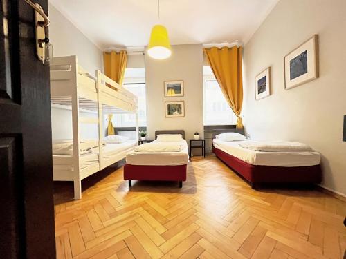 two beds in a room with two bunk beds at Hostel Helvetia - PRIVATE ROOMS in CITY CENTER and OLD TOWN in Warsaw