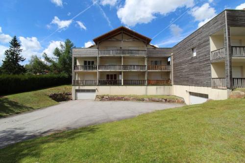 un edificio de apartamentos con una entrada delante de él en Le petit bonhomme de neige, en Gérardmer