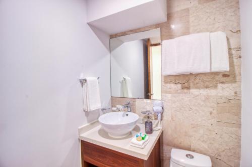 a bathroom with a sink and a toilet and a mirror at One Paralia 405 in Playa del Carmen