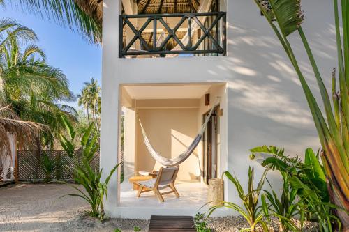 a room with a hammock in a house on the beach at Casa Kuaa in Brisas de Zicatela