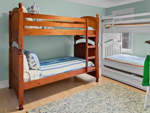 two bunk beds in a room with a rug at 31 Pine Road West Dennis Cape Cod - - Shark Lookout in West Dennis