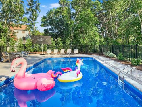 a pool with two inflatable flamingos in the water at 31 Pine Road West Dennis Cape Cod - - Shark Lookout in West Dennis