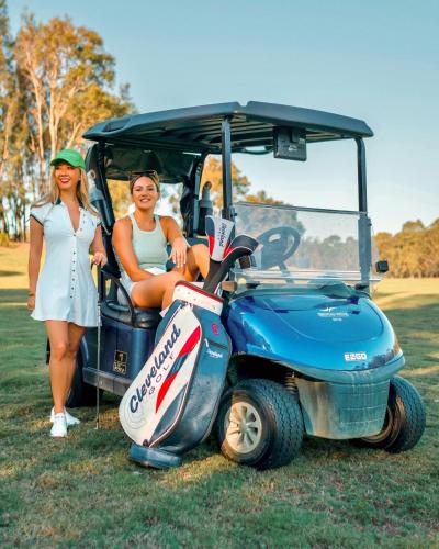 two women are standing next to a golf cart at Mercure Kooindah Waters Central Coast in Wyong