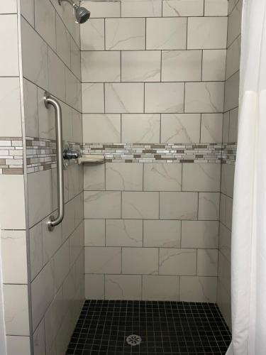y baño con ducha de azulejos blancos. en Starlite Resort en Saugatuck
