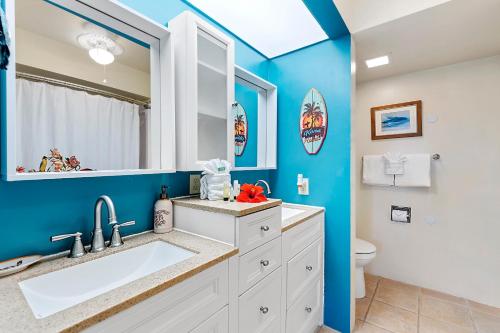 a bathroom with blue walls and a sink and a toilet at Casa De Emdeko 222 in Kailua-Kona