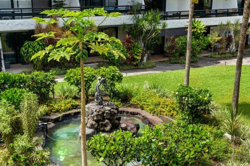 a garden with a fountain in the middle of a building at Casa De Emdeko222 in Kailua-Kona