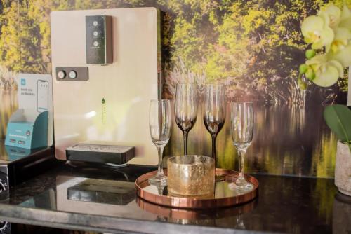 três copos de vinho sentados num balcão ao lado de uma parede em 1 Bedroom Guest House with Sauna and Steam Room em Kent