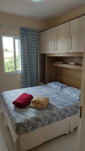 ein Schlafzimmer mit einem großen Bett mit zwei Kissen darauf in der Unterkunft Apto novo em Condominio com vista as Montanhas. in Serra Negra