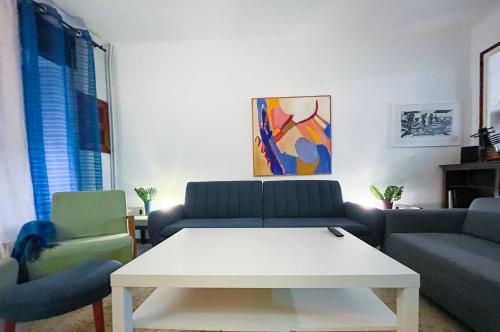 una sala de estar con 2 sofás y una mesa blanca. en Revenon2023Maison retro dans le centre historique, en Palafrugell