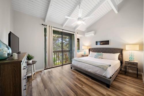 a bedroom with a bed and a large window at Kuilima Estates West 120 in Kahuku