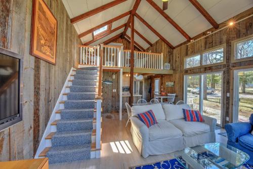 a living room with a staircase in a tiny house at Sun Serenity at A Wave From It All in Pocasset