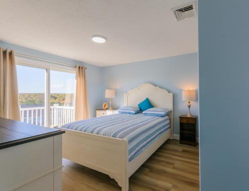 un dormitorio con una cama y una ventana en 129 North Shore Boulevard East Sandwich - Cape Cod, en East Sandwich
