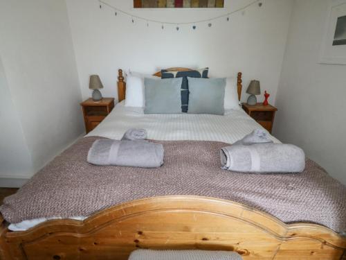 ダートマスにあるGlen Cottageのベッドルーム1室(木製ベッド1台、タオル付)