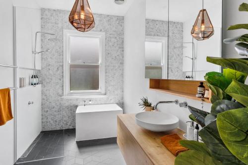 a white bathroom with a sink and a mirror at Bellarine cottage- Central Geelong, parking, 2 bedroom, 2 bathroom in Belmont