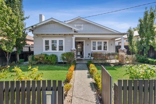 a white house with a fence in front of it at Bellarine cottage- Central Geelong, parking, 2 bedroom, 2 bathroom in Belmont