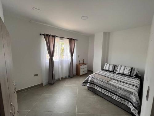 a bedroom with a bed and a window at Hermoso y amplio apartamento en Guatapé in Guatapé