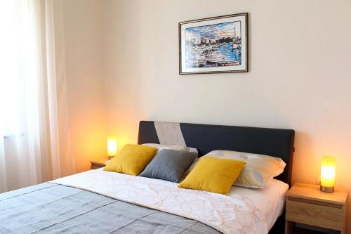 una camera da letto con letto e cuscini gialli di Apartments with a parking space Opric, Opatija - 7753 a Lovran (Laurana)