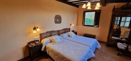 a bedroom with a bed with a blue comforter at El Mirador de Deva in Deva
